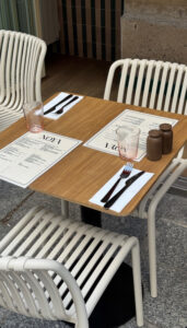 Person sitting at a table with a coffee, looking thoughtful, representing the internal experience of a complicated relationship with food without depicting food or eating behaviours